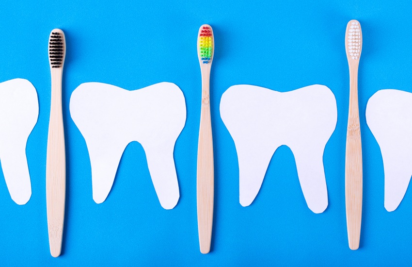 paper cut out teeth with toothbrushes on a blue background