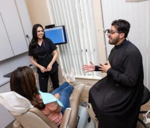 Dr. Niko and a dental assistant talking with a patient about the importance of dental sealants.