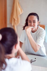 Beauty girl in bathroom cleaning teeth in the morning time.